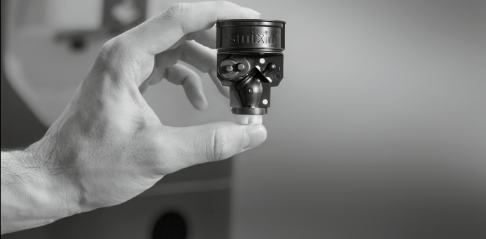 A Smixin Smart Mixing Unit held in a hand