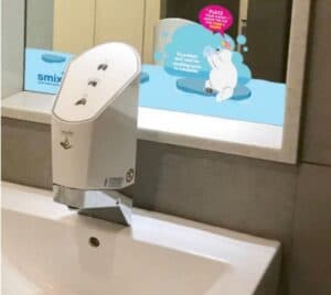 Smixin touch-free handwashing dispenser above a school washbasin