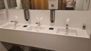 Smixin touch-free dispensers installed above a multi-user washbasin